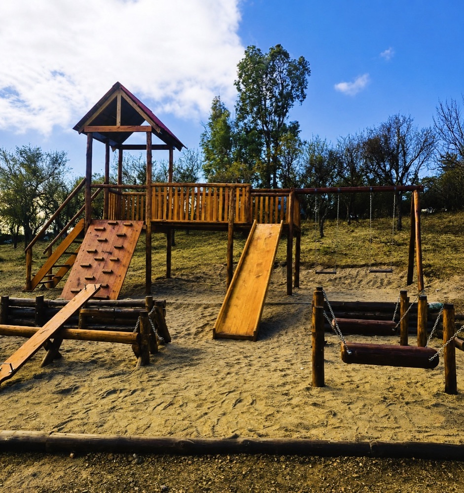 Sector de juegos de madera para niños, con tobogán, hamacas y muro de escalada